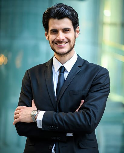 Professional man in a suit smiling confidently, representing expert consulting services for business growth and marketing strategies.