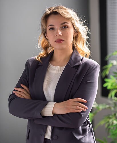 Professional woman in a blazer with arms crossed, representing expertise in marketing and consulting for Carolina Hyperbaric & Wellness.