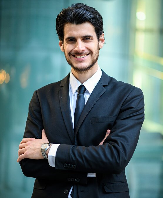 Professional man in a suit smiling confidently, representing the team at Carolina Hyperbaric & Wellness, highlighting expertise in health and wellness services.